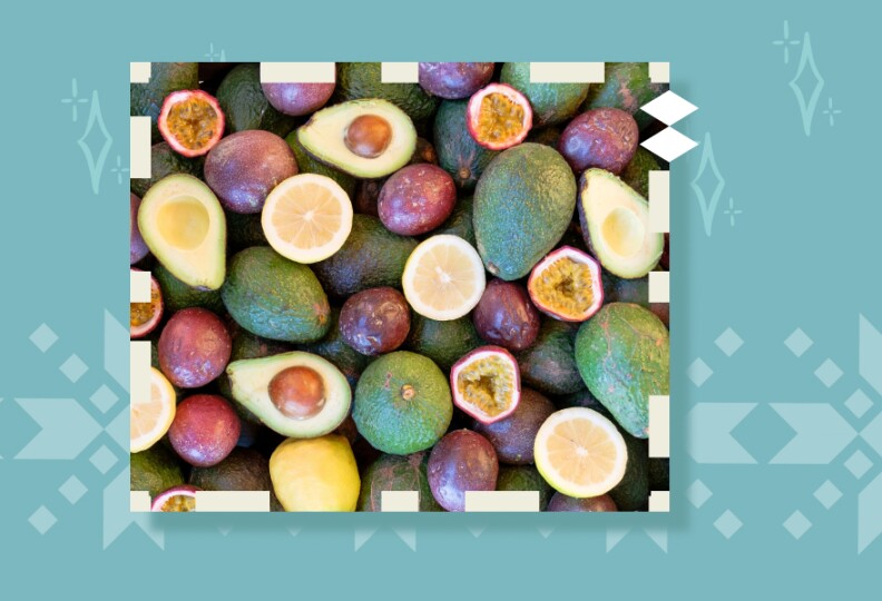 A wooden box filled with avocado, lemons and passion fruit.