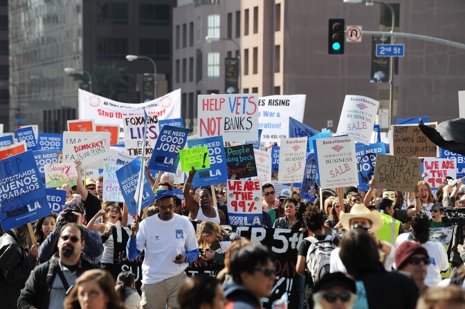 Occupy LA protestors march through the downtown Los Angeles financial district. Police Chief Charlie Beck announced Tuesday a timeline for closing the LA City Hall encampment.