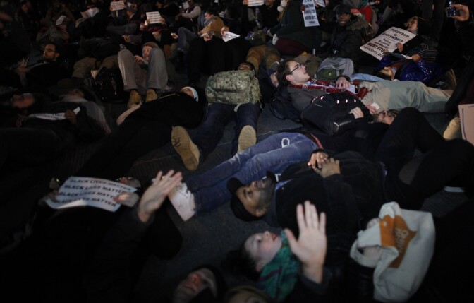NEW YORK, NY - DECEMBER 3: People lie down in the street as they take part during a protest in support of Eric Garner at the Columbus Circle on December 3, 2014 in New York City. Garner died after being put in a chokehold during an alteration with NYPD officers in the Staten Island borough of New York City. (Photo by Kena Betancur/Getty Images)
