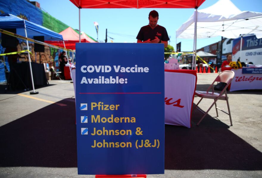 LOS ANGELES, CALIFORNIA - JUNE 25: A sign displays the types of COVID-19 vaccination doses available at a Walgreens mobile bus clinic on June 25, 2021 in Los Angeles, California. The United States will miss President Joe Biden's goal of delivering at least one coronavirus vaccine dose to 70 percent of adults by the July 4th holiday. (Photo by Mario Tama/Getty Images)