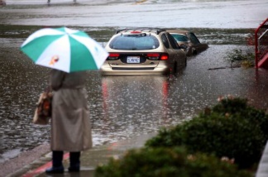 A vehicle sits partially submerged after flood waters rose in the San Diego River.