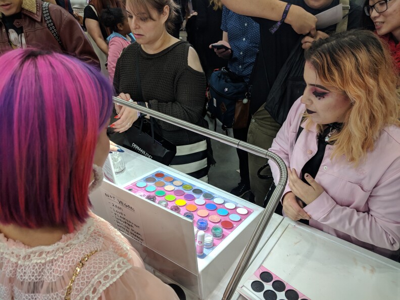 Marissa Lara, 22 (R), browses the eyeshadow options at Sugarpill's vendor booth during RuPaul's DragCon LA 2018. Sugarpill is an LA-based company specializing in make-up with vibrant hues.