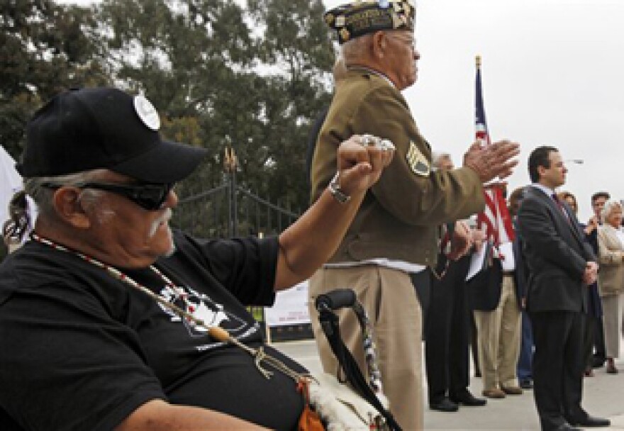 Veteran J.J. Asevedo raises a clenched fist at a news conference to announce a lawsuit against the federal government, alleging the misuse a 390-acre plot of land in West Los Angeles that was donated some 130 years ago to house veterans who need care after traumatic military experiences, at the Los Angeles Veterans Administration center in Los Angeles Wednesday, June 8, 2011. 