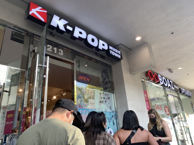 A man and several women stand in line waiting to get inside KPop Music Town.