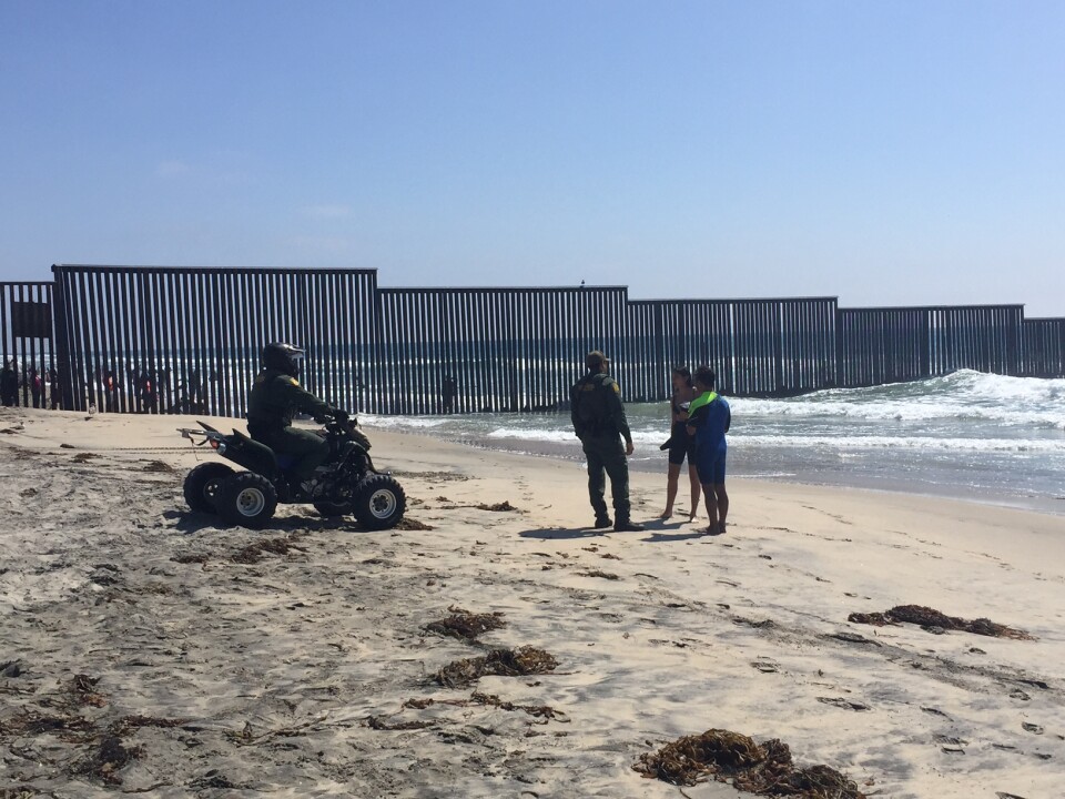 U.S. Customs and Border Patrol agents talk with participants in the "Surf Border" event at Border Field State Park in San Diego on August 12th, 2017.