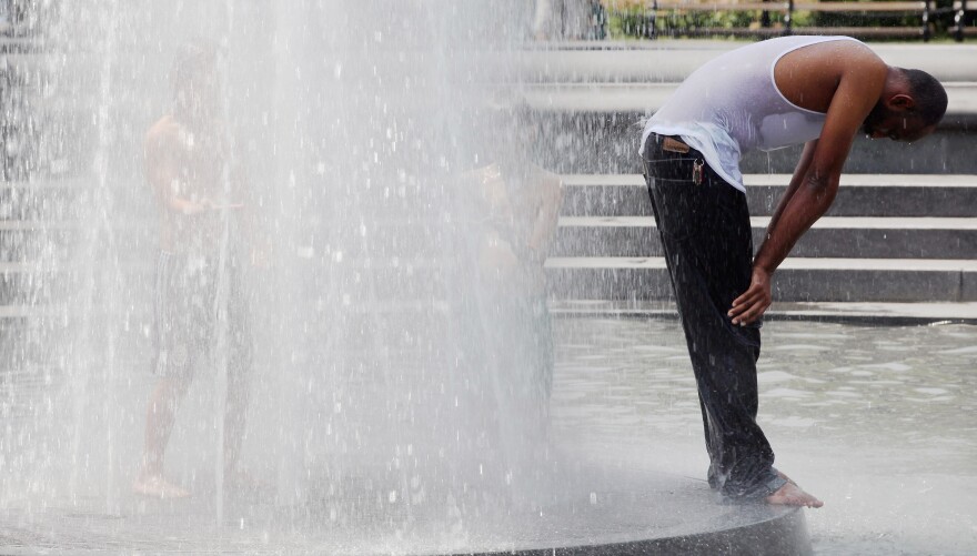 NEW YORK, NY - JULY 18:  A man stands in a fountain in Washington Square Park on July 18, 2012 in New York City. Temperatures were expected in the upper 90's during another heat wave in the city.  (Photo by Mario Tama/Getty Images)