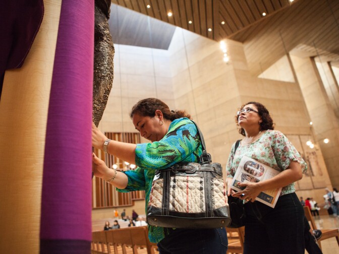 Maria Jesus Perez and Patricia Perez touch the feet of Jesus at the Cathedral of Our Lady of the Angels on March 13th, 2013.