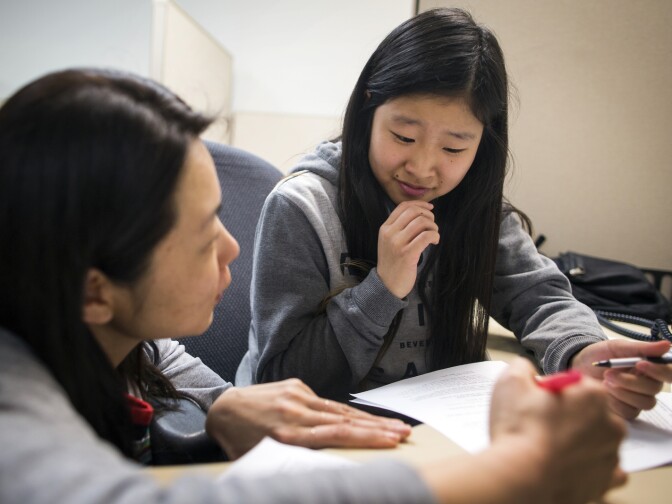 Lia Kim, a Korean teacher at the Los Angeles Center for Enriched Studies, works with ninth-grader Nara Hong on a call script in Korean during a phone bank shift reminding people to vote in the upcoming primary election at the Asian Americans Advancing Justice Los Angeles on Monday evening, May 23, 2016. The students are volunteering through the K.W. Lee Center for Leadership.
