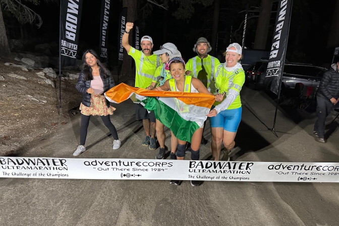 A group of diverse people celebrating at the finish line of a race at night