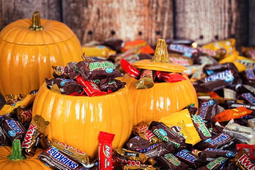 Stacks of name-brand candy pour out of ceramic pumpkins.