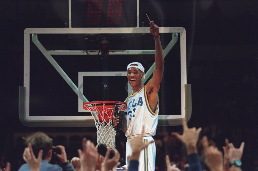 In this file photo, then-UCLA forward Ed O'Bannon celebrates by cutting his part of the net after the Bruins' 102-96 win over UConn in the NCAA West Regional Final at the Oakland Coliseum in Oakland, California in March 1995. Some believe O'Bannon's legal crusade against the NCAA will upend the way college sports operate.