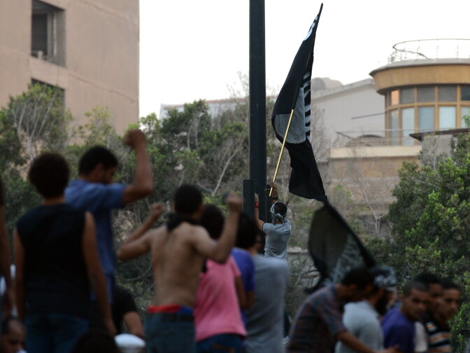 Egyptian protesters raise inside the US embassy a black flag inscribed with the Muslim profession of belief: 'There is no God but God and Mohammed is the prophet of God' during a protest against a film deemed offensive to Islam in Cairo on September 11, 2012.