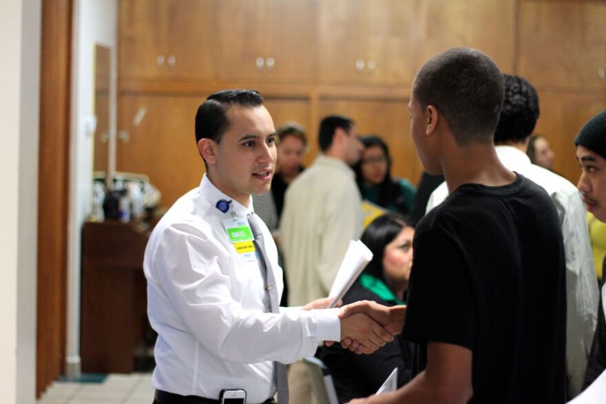 Daniel Vera, assistant manager at the Altadena Walmart Neighborhood Market, greets job seekers at the "Hiring Altadena" event.