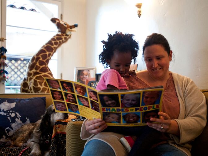 Trista and Luli Schroeder read "Shades of People," one of several books that Schroeder says has helped start the discussion of color with her three-year-old daughter. They read the book at least two to three times each week.
