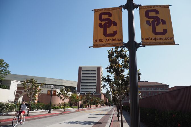 A young man rides a bicycle on the campus of the University of Southern California (USC) in Los Angeles, California on May 17, 2018. - USC was in turmoil as it was accused of being too slow to act on accusations of abusive sexual practises by Dr. George Tyndall. A gynaecologist who saw student patients at the Engemann Student Health Center.  USC has already received more than 85 current and former student testimonies accusing Tyndall of abuse during examinations. (Photo by Robyn Beck / AFP)        (Photo credit should read ROBYN BECK/AFP/Getty Images)