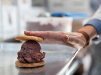 Natasha Case, co-founder of Coolhaus, places a cookie on a scoop of ice cream inside once of their food trucks on Wednesday, May 28. Coolhaus just published a "cook" book.