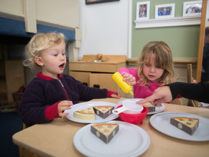 Tilda and Caroline prtend to eat dinner at the Child Educational Center.