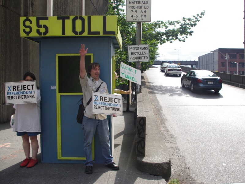 Volunteers with Protect Seattle Now set up a mock toll booth at a downtown  entrance to the Alaskan Way Viaduct, to remind drivers that they'll have to pay  to use the planned tunnel.