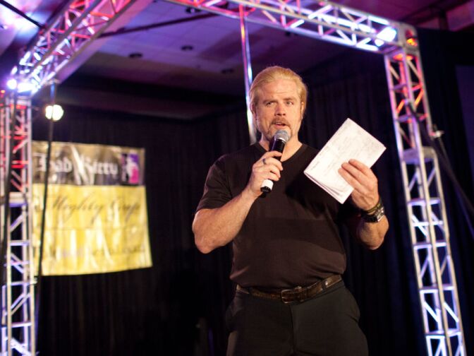 The master of ceremonies on the main stage of the International Pole Dancing Convention announces the next act.