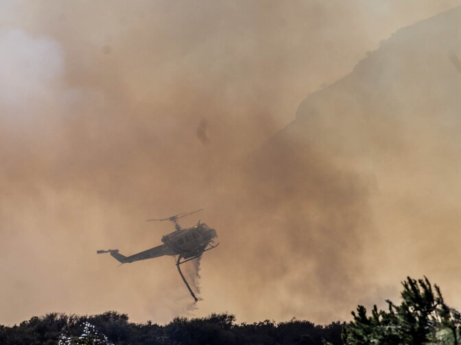A helicopter from Kern County drops water on a brushfire in the unincorporated Newbury Park neighborhood west of Thousand Oaks in Ventura County on May 2, 2013.
