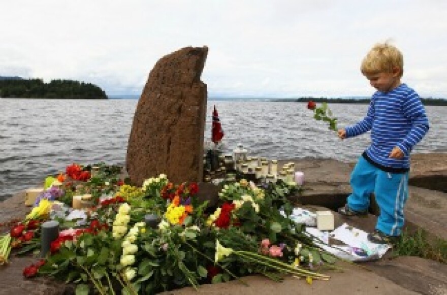 A young boy lays a flower opposite Utoya Island, following Friday's twin extremist attacks on July 25, 2011 in Utoya, Norway.