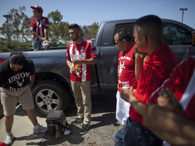 Chivas fans Paola Espinosa, left, Allen Duran, 9, Harat Espinosa, Jr., his father, Harat Espinosa, and Juan Gutierrez tailgate before a LA Galaxy versus Chivas Major League Soccer game at the StubHub Center in Carson. The group is rooting for Mexico during the World Cup.