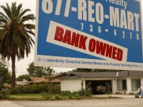 A realtor sign advertises a bank-owned house for sale in Pasadena. The U.S. government filed a lawsuit in District Court in Los Angeles, accusing the debt rating agency Standard & Poor's of fraud for giving high ratings to risky mortgage bonds that helped bring about the financial crisis. 
 (Photo by David McNew/Getty Images)