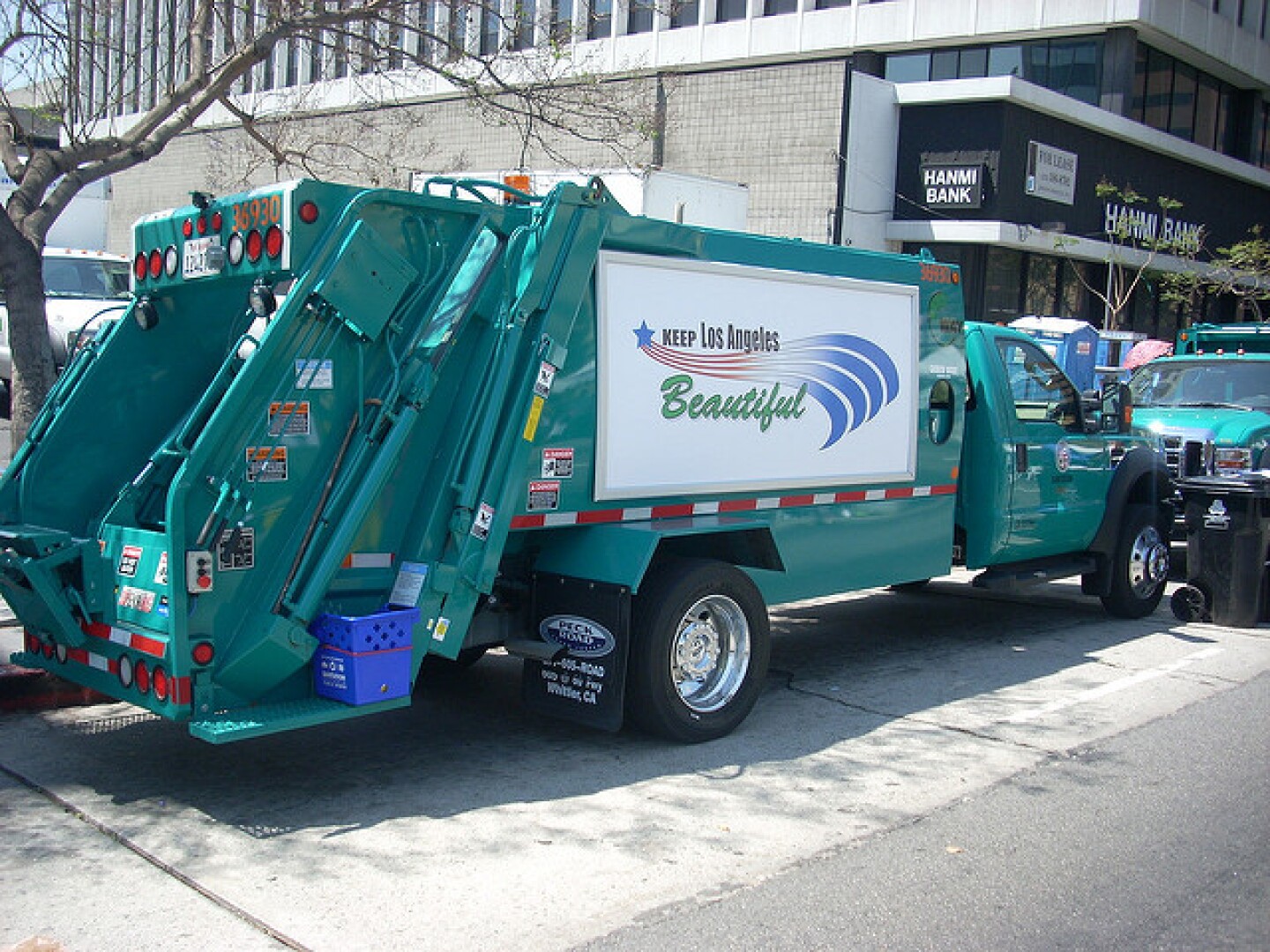 An image of a green garbage truck with a large sign on its side that reads Keep Los Angeles Beautiful