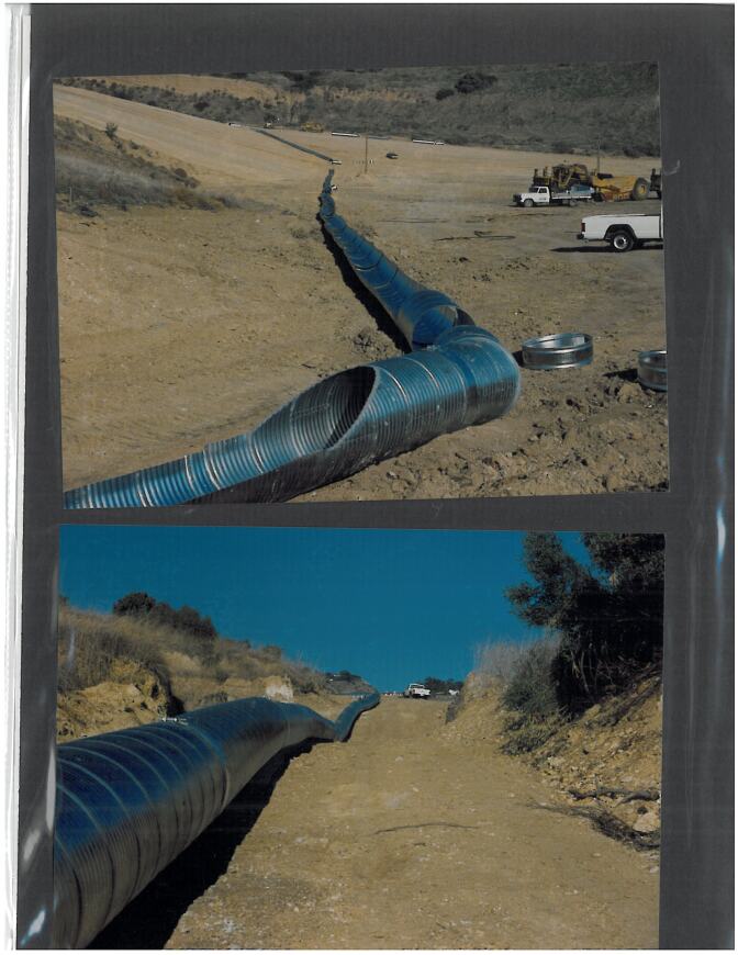 Metal piping winds through a hillside. 