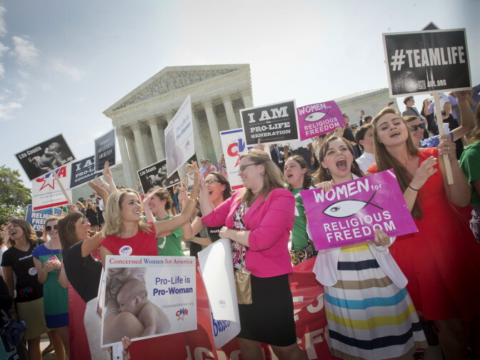 Demonstrator react to hearing the Supreme Court's decision on the Hobby Lobby case outside the Supreme Court in Washington, Monday, June 30, 2014. The Supreme Court says corporations can hold religious objections that allow them to opt out of the new health law requirement that they cover contraceptives for women.(AP Photo/Pablo Martinez Monsivais)