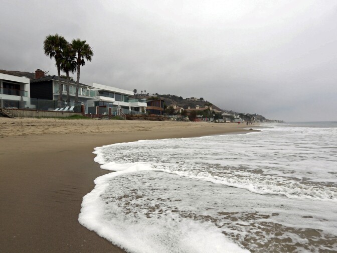 Visitors are few at Carbon Beach, the so-called "Billionaires' Beach," on the first day of the opening of a new access route in Malibu, Calif., Tuesday, July 7, 2015. The California Coastal Commission officially opened a third public path to Carbon Beach on Tuesday, allowing the not-so-rich-and-famous access to the sandy backyards of oceanside mansions. (AP Photo/Nick Ut)