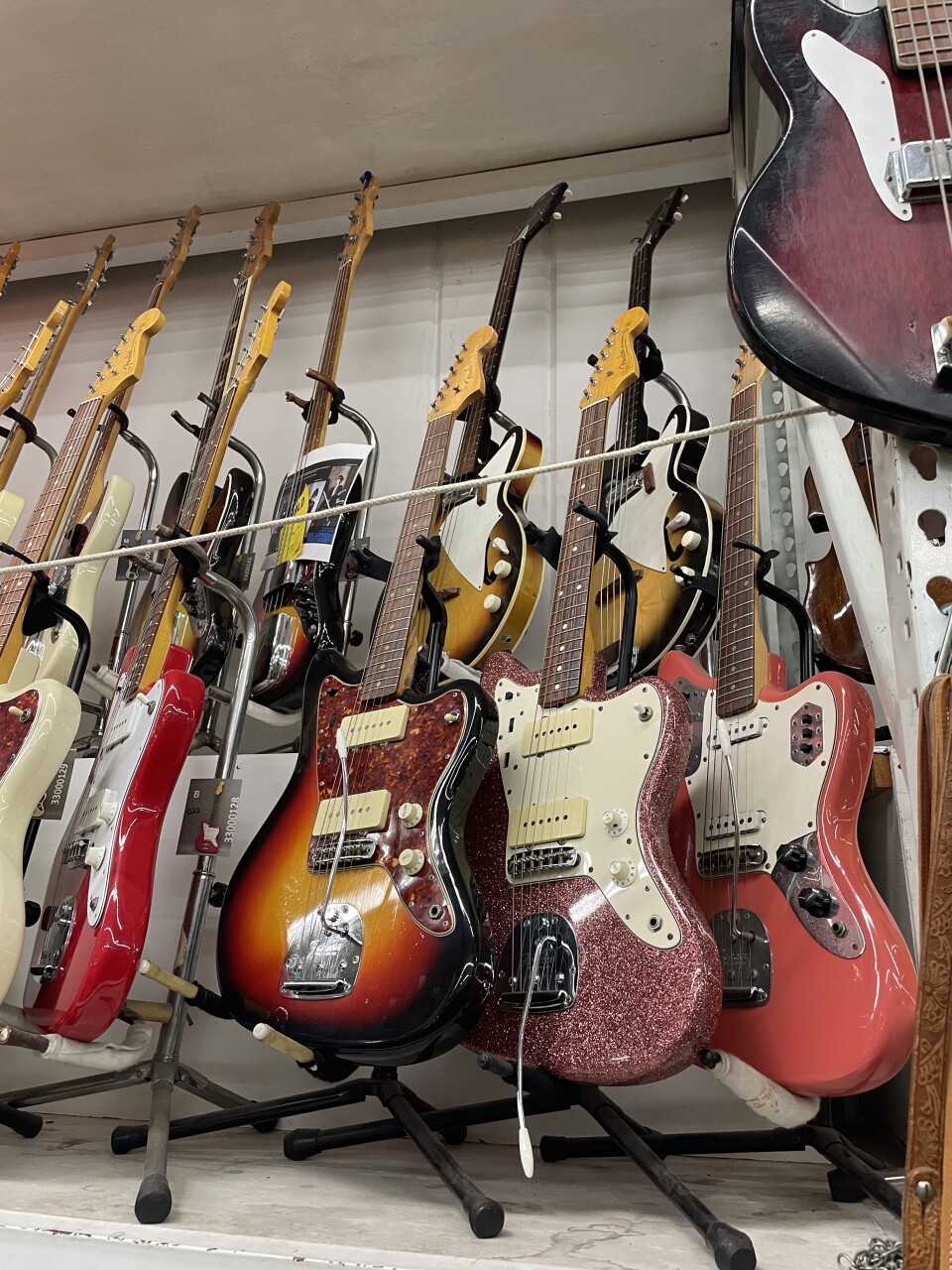 Almost a dozen glittery, colorful electric guitars line a wall at a Burbank prop house. 
