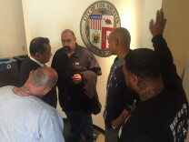 Jose Osuna (middle) and trainees of Homeboy Industries meet with Councilman Gil Cedillo after a minimum wage vote.