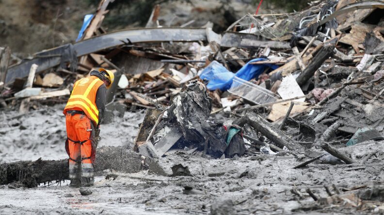 A worker uses a chain saw at the scene of the deadly mudslide near Oso, Wash.

