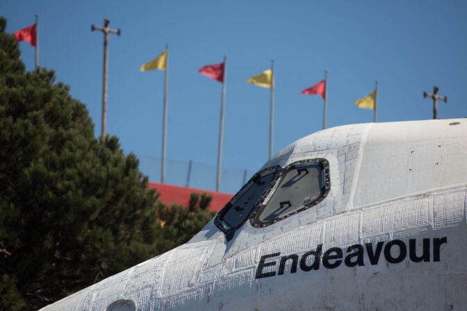The Space Shuttle Endeavour makes its way past the cardinal and gold of the Trojans near the California Science Center on Sunday.