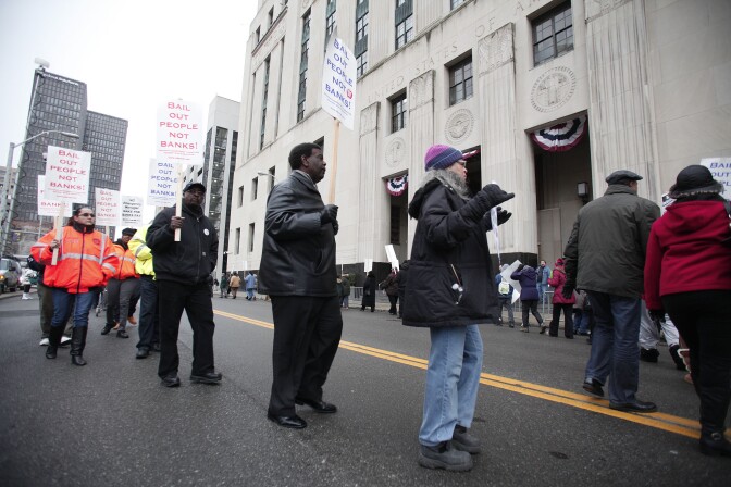 People protest outside the U.S. Courthouse where federal bankruptcy Judge Steven Rhodes is to rule on Detroit's Chapter 9 bankruptcy eligibility December 3, 2013 in Detroit, Michigan. Judge Rhodes ruled that the city is eligible for bankruptcy protection and that pensions can be cut. Detroit is the largest city in U.S. history to file for bankruptcy. How will it's bankruptcy affect California?