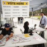 LOS ANGELES, CALIFORNIA - FEBRUARY 27: A voter (2nd R) checks in before entering a voting booth during early voting for the California presidential primary election at a new L.A. County ‘Mobile Vote Center’ in Grand Park on February 27, 2020 in Los Angeles, California. Los Angeles County and several other counties in California have transitioned from polling places to ‘vote centers’ which allow residents the freedom to vote in any vote center in the county. California is one of 14 states participating in the Super Tuesday vote on March 3.  (Photo by Mario Tama/Getty Images)