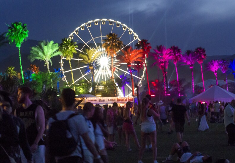 Colored lights illuminate palm trees on the first day of the Coachella Music Festival, in Indio, California, April 10, 2015.  AFP PHOTO / ROBYN BECK        (Photo credit should read ROBYN BECK/AFP/Getty Images)