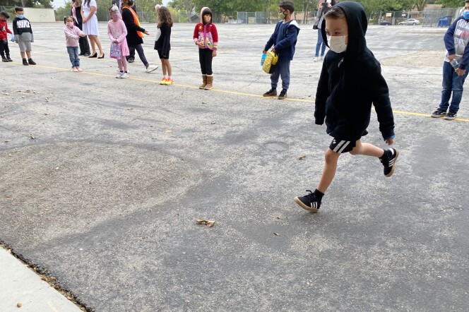 A first grader bounds toward a restroom on the campus of Brainard Avenue Elementary in Lake View Terrace. L.A. Unified School District campuses follow rules requiring six feet of distance between all staff and students at a time -- which means restroom capacity is limited.
