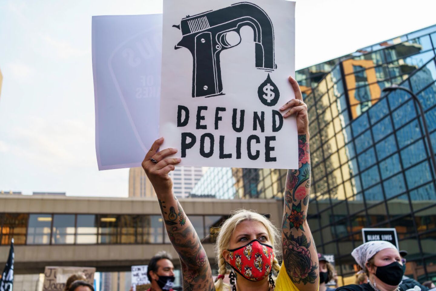 A protester holds a sign that reads "Defund the Police" outside Hennepin County Government Plaza during a demonstration against police brutality and racism on Aug. 24, 2020 in Minneapolis, days following the shooting of Jacob Blake in Kenosha, Wisconsin.