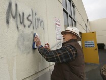 File: In this Feb. 1, 2017 file photo, Tom Garing cleans up racist graffiti painted on the side of a mosque in what officials are calling an apparent hate crime in Roseville, Calif. California's attorney general says the number of hate crimes increased about 11 percent last year, the second consecutive double-digit increase after years of decline. The report released Monday, July 3, 2017, shows 931 hate crimes statewide in 2016, nearly 100 more than in 2015.