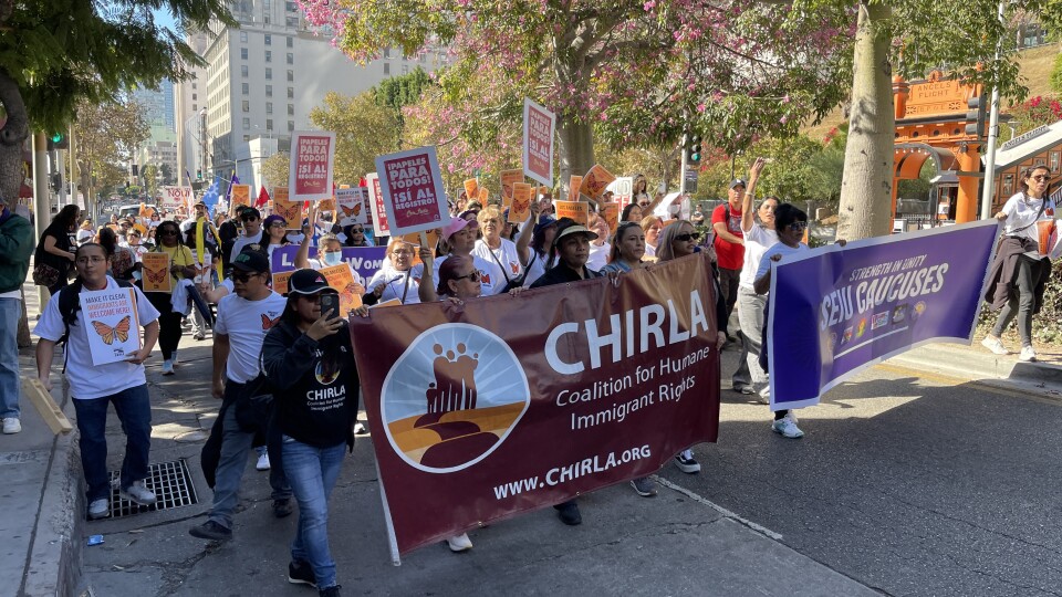 People marching holding a CHIRLA banner