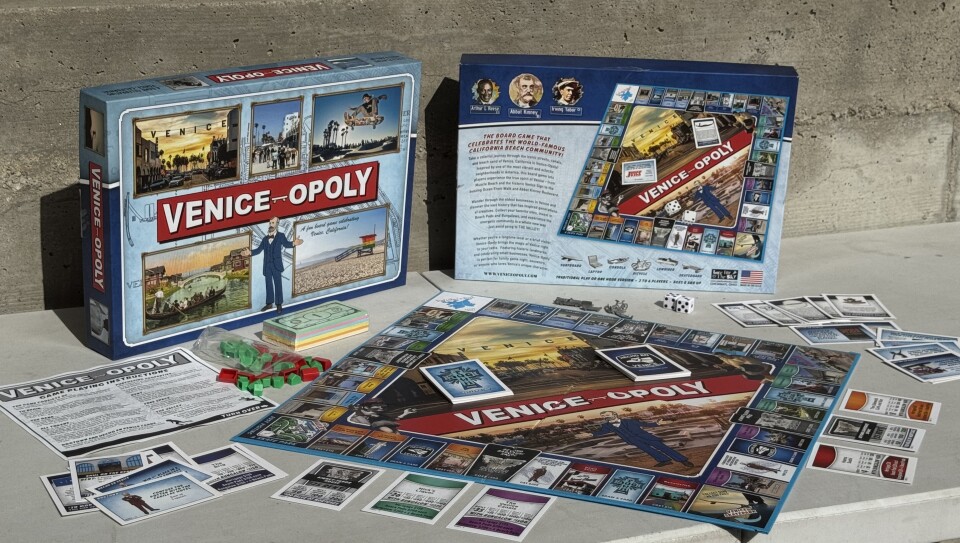 A board game called Venice-opoloy is laid out on a bench, including its board, the different pieces and cards.