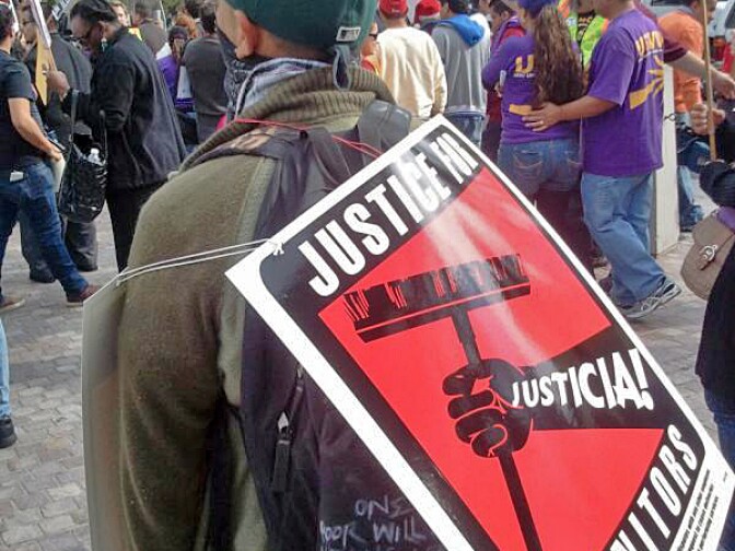 SEIU union protest sign calling for justice for janitors as protesters march to downtown L.A. federal building to protest immigration policy, Dec. 15, 2011.