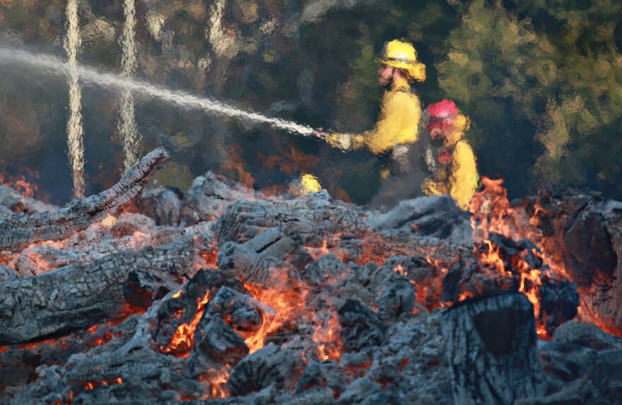 MALIBU, CA - NOVEMBER 11: Firefighters battle a blaze at the Salvation Army Camp on November 10, 2018 in Malibu, California. The Woolsey fire has burned over 70,000 acres and has reached the Pacific Coast at Malibu as it continues grow.  (Photo by Sandy Huffaker/Getty Images)