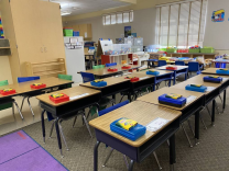 A children's classroom with pencil boxes and desks lined up in rows