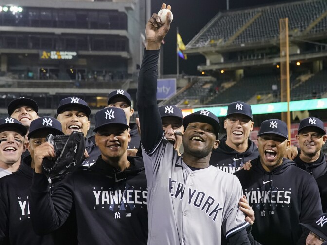 New York Yankees pitcher Domingo Germán, center, poses for a photograph with the team after his perfect game against the Oakland Athletics during a baseball game in Oakland, Calif., Wednesday, June 28, 2023.