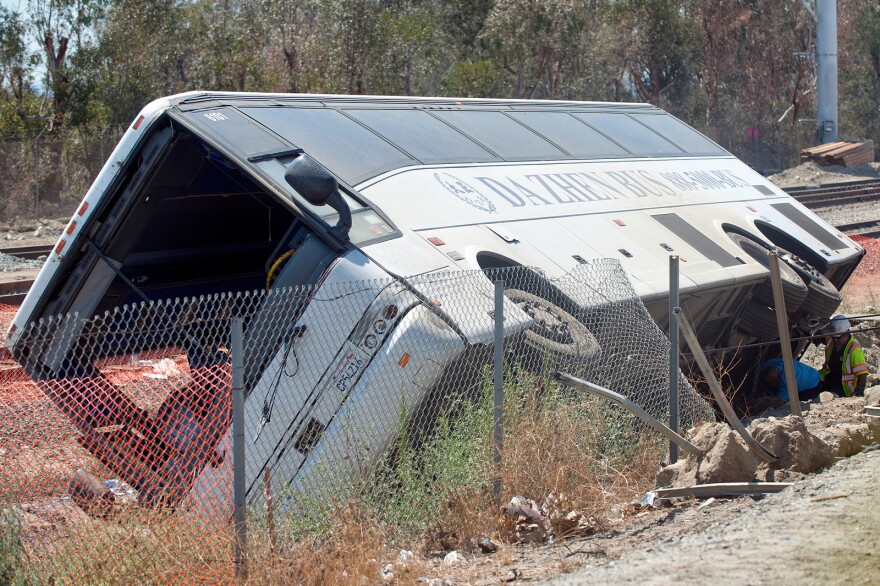 Crews attach cables to the underside to the bus as they pull it upright. More than 50 were injured when a charter bus overturned on the 210 East in Irwindale on Thursday morning, Aug. 22.