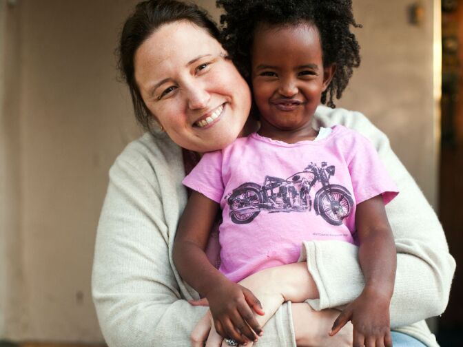 Trista Schroeder and her daughter, Luli, 3, sit outside their home on Monday afternoon. Schroeder adopted Luli at birth in Ethiopia.