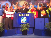 Tefere Gebre (left in the blue shirt) joins other members of the AFL-CIO – including President Rich Trumka in the suit behind the podium – during the union's convention in downtown Los Angeles on Sept. 9, 2013.